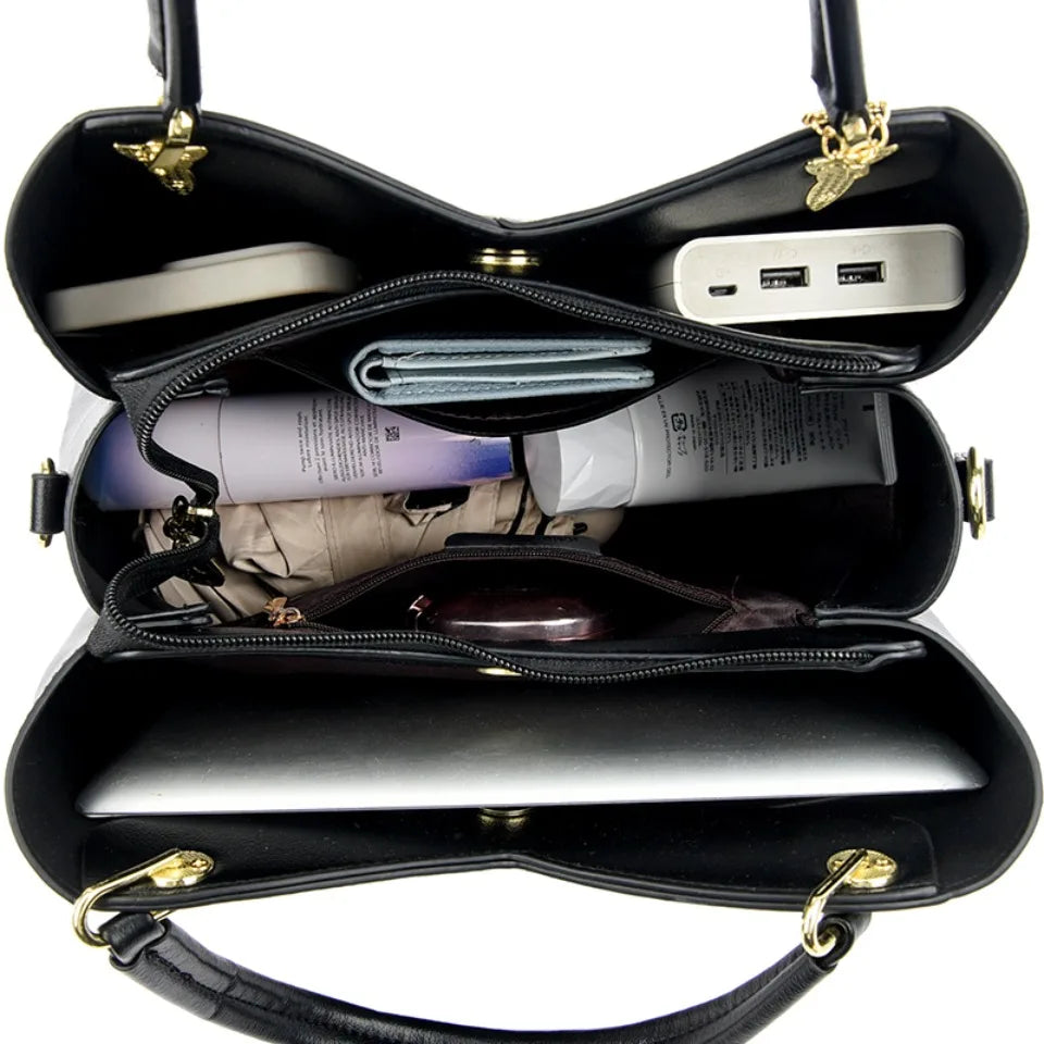 felina™ – sort skuldertaske med elegante vedhæng